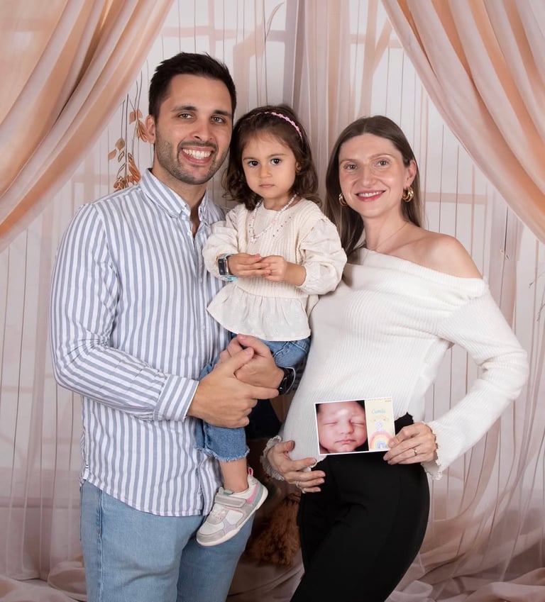 Família a segurar um cartão com a imagem digital do bebé antes de nascer
