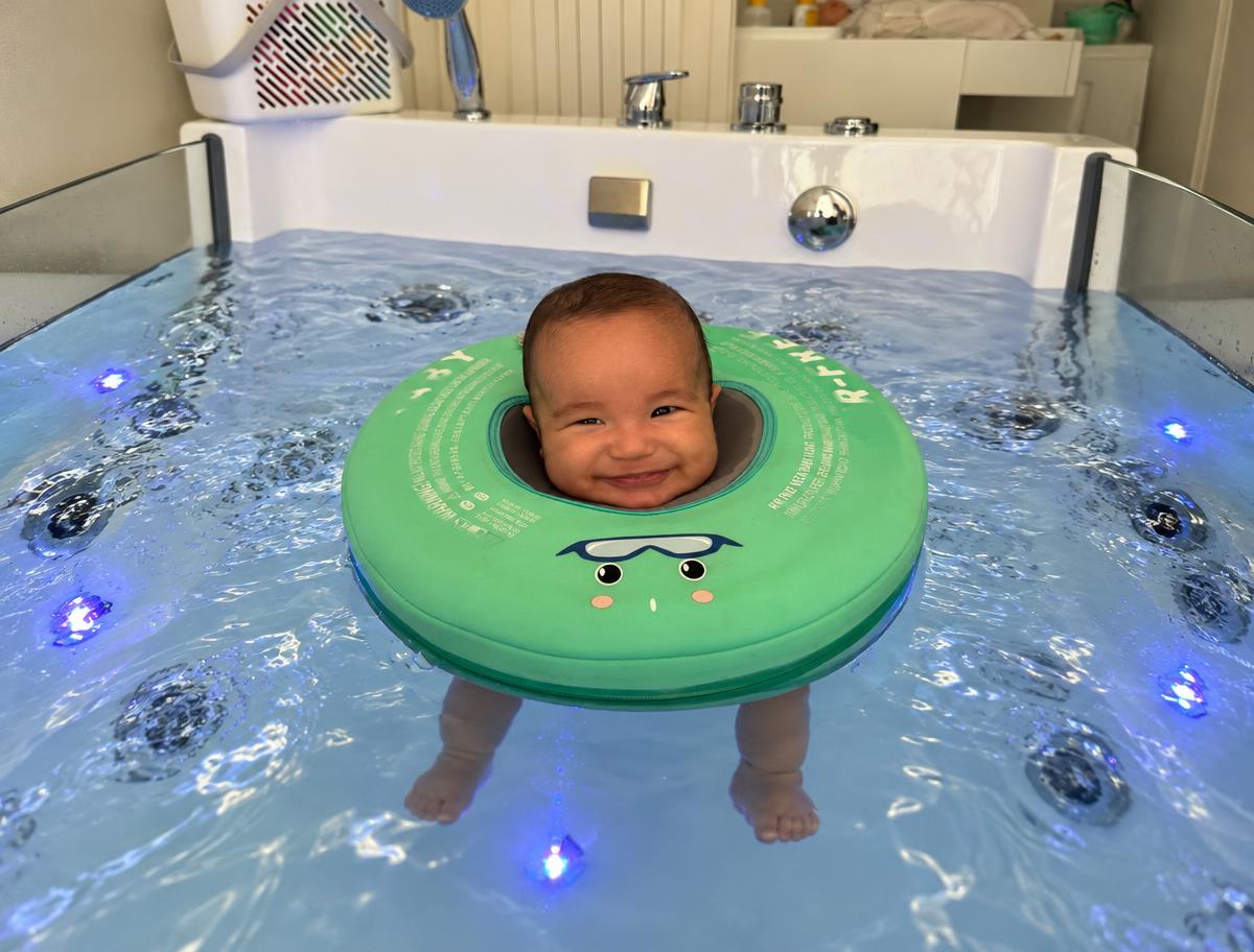 Bebé a sorrir enquanto flutua numa sessão de Baby Spa